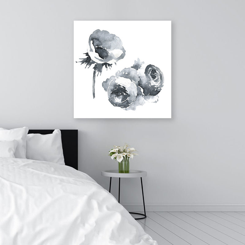 Black and white canvas art print of flowers on a white background, displayed in a monochromatic, minimalist bedroom.