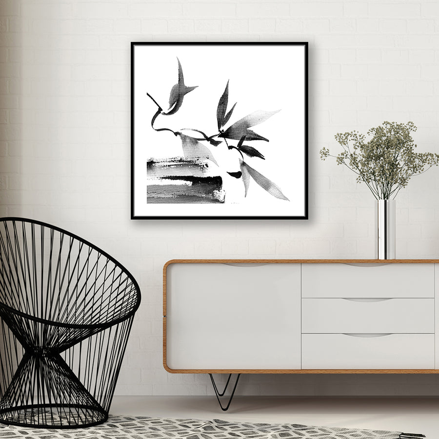 Black and white Japanese-style wall art print of twigs and leaves, in a modern, minimalist interior.