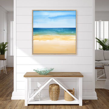 Watercolour canvas art print of a turquoise sea, coral sandy beach and clear azure blue sky, in a coastal-style interior.