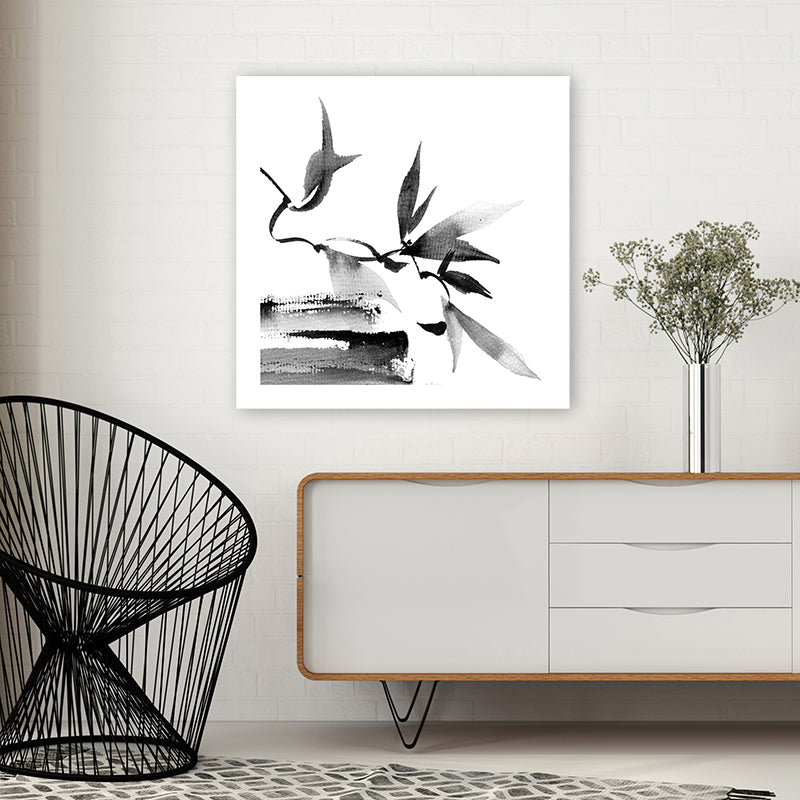 Black and white Japanese-style wall art print of twigs and leaves, in a modern, minimalist room.