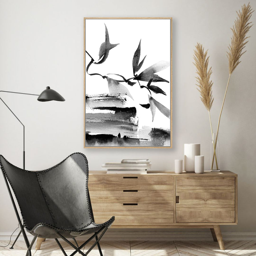 Black and white Japanese ink framed art print of leaves and branches, in a modern, minimalist interior.